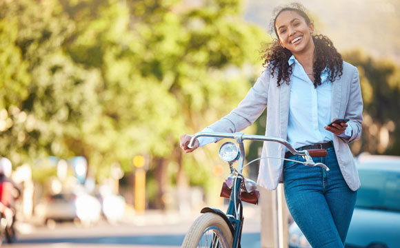 sonriente chica jóven con un bici 