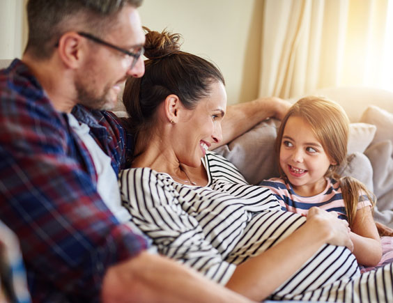 Niña tocando la barriga de su madre embarazada