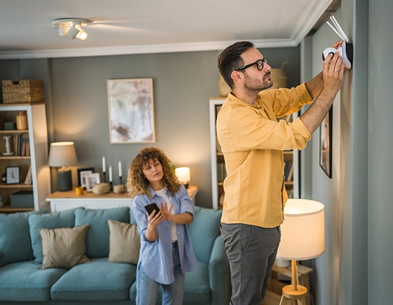 Persona colocando una cámara de vigilancia dentro de su casa