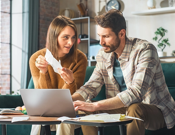 Pareja revisando documentos y escribiéndolo en el ordenador
