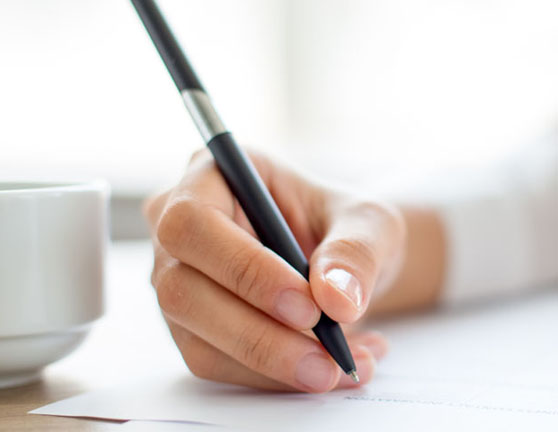 Persona firmando un documento sobre una mesa