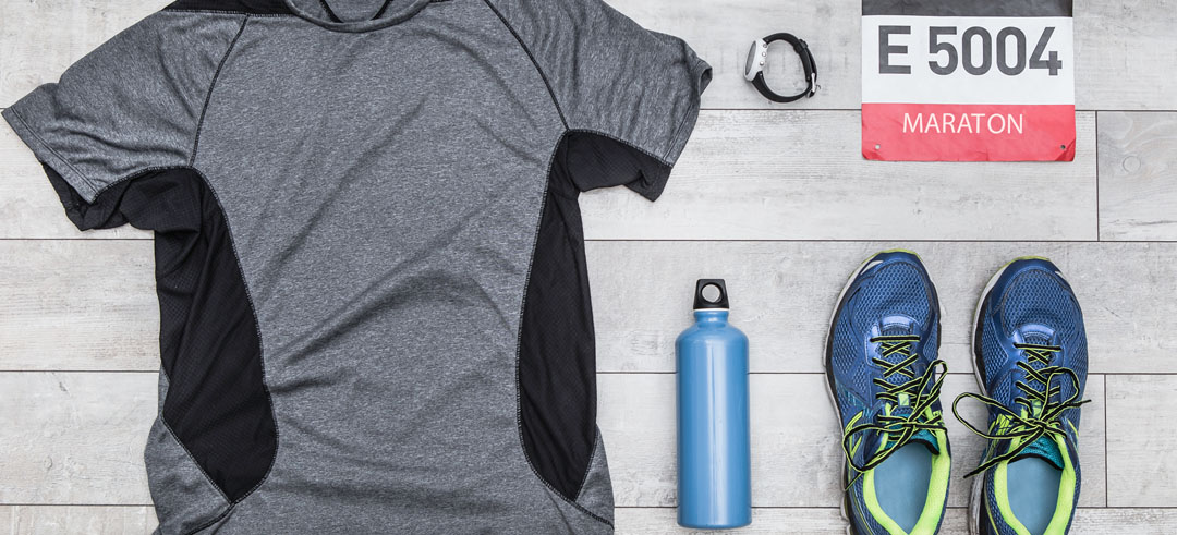 Camiseta, zapatillas, botella, reloj y dorsal para una maratón