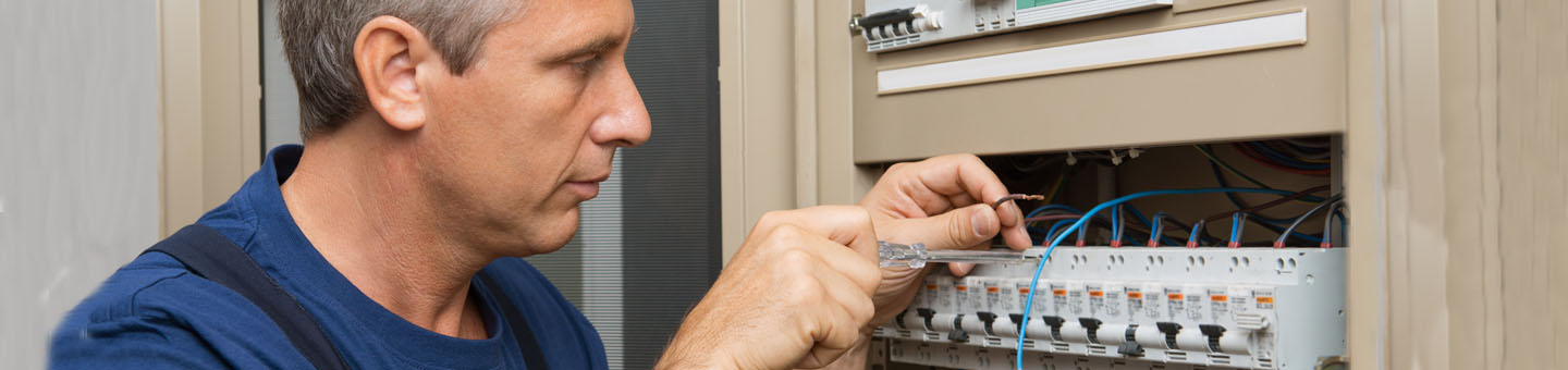 Hombre reparando el cuadro eléctrico en una casa